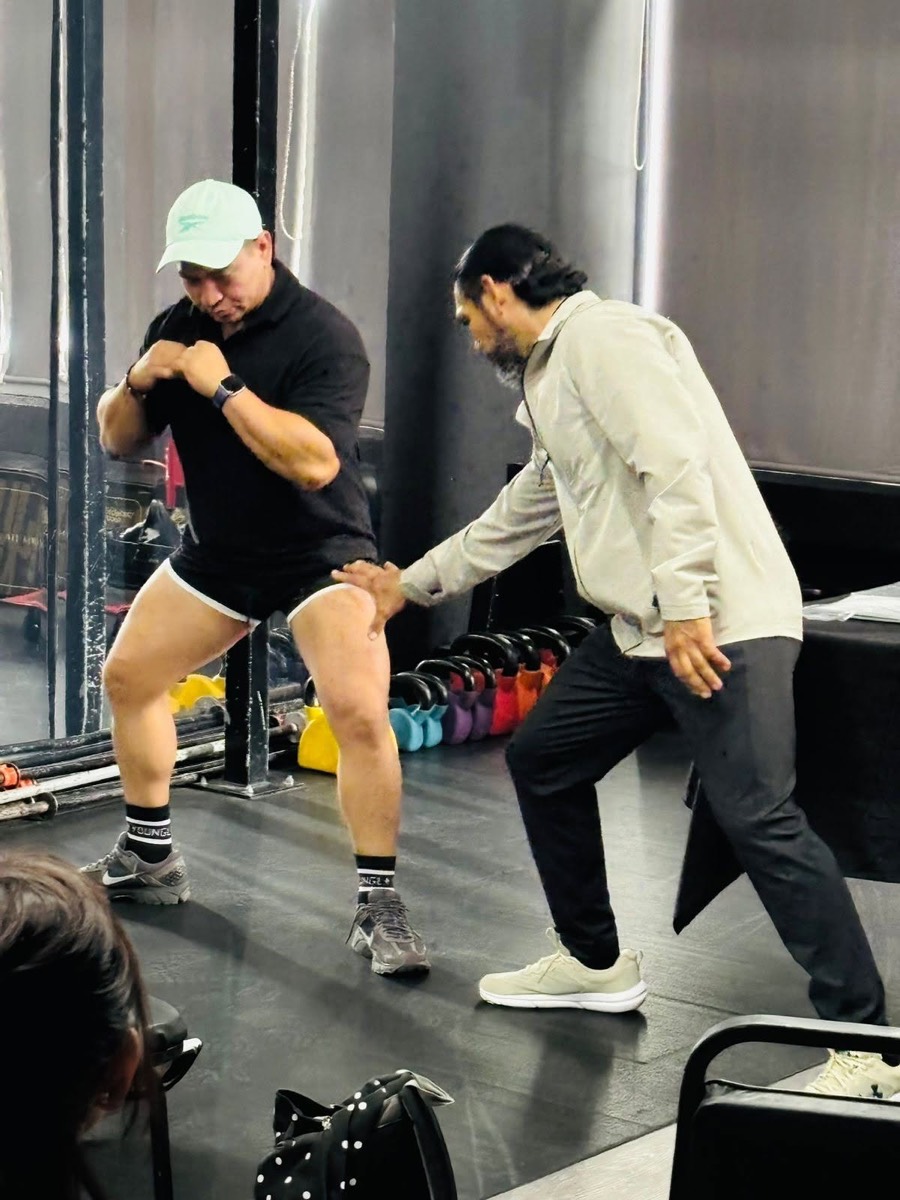 Miguel ajustando la postura de un atleta durante una asesoría