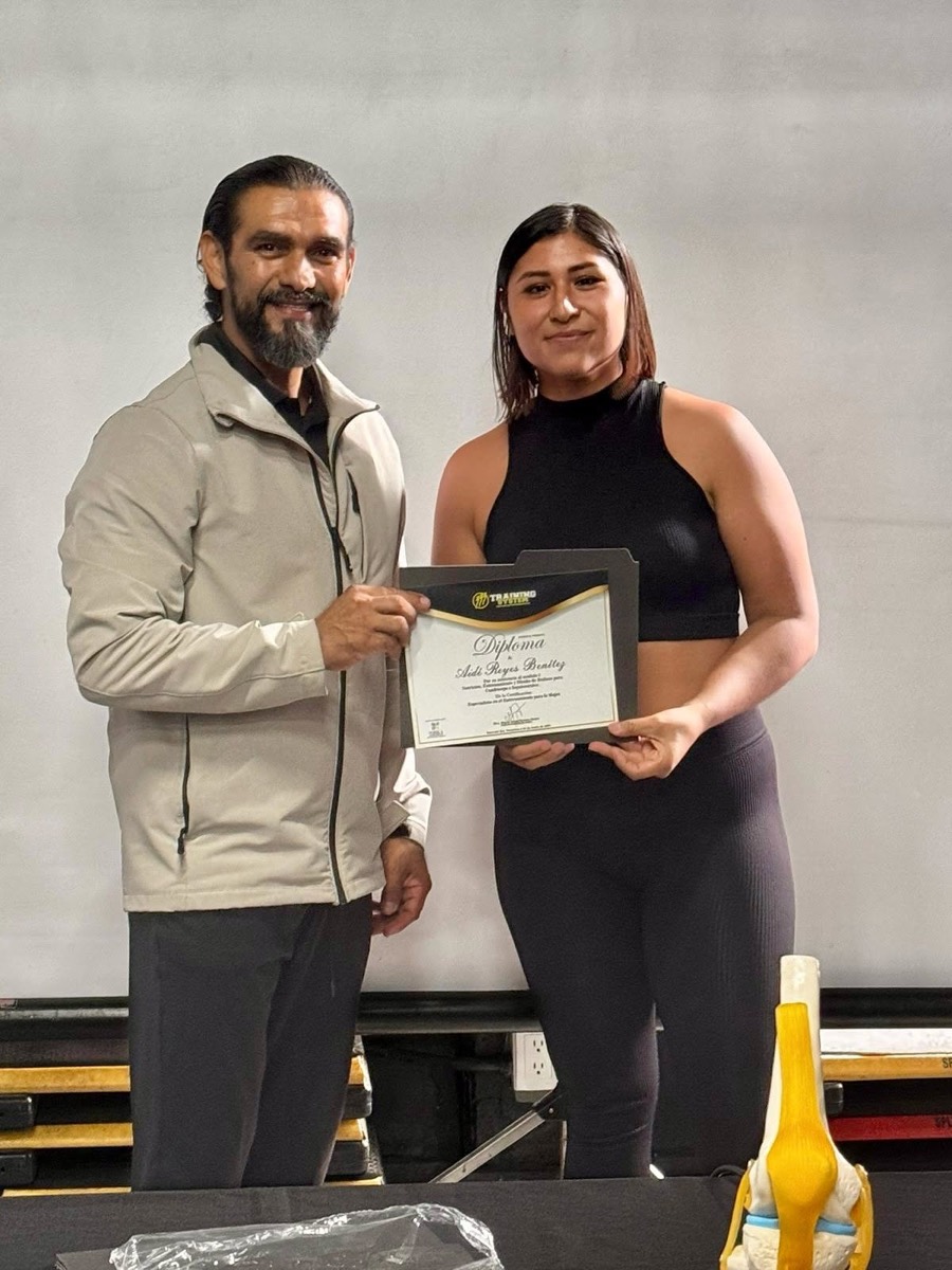 Miguel entregando su diploma a una alumna al término de una capacitación