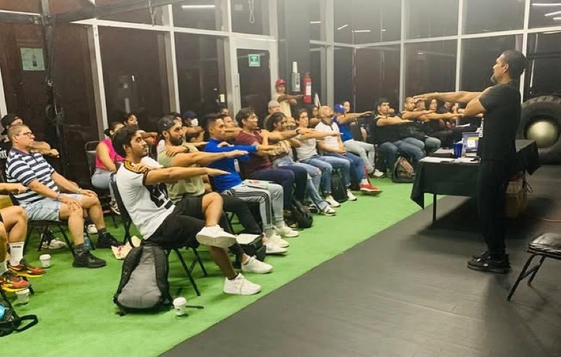 Miguel dirigiendo a un grupo de coaches que replican un movimiento en el aula